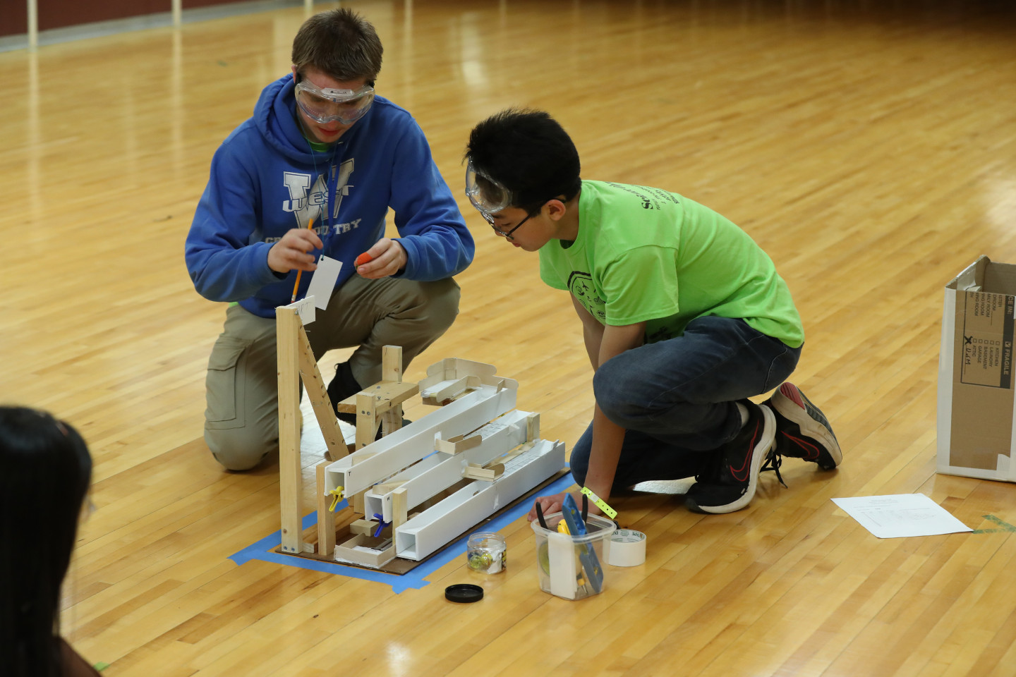 A WMU student assists a participant in the Regional Science Olympiad event held at WMU.