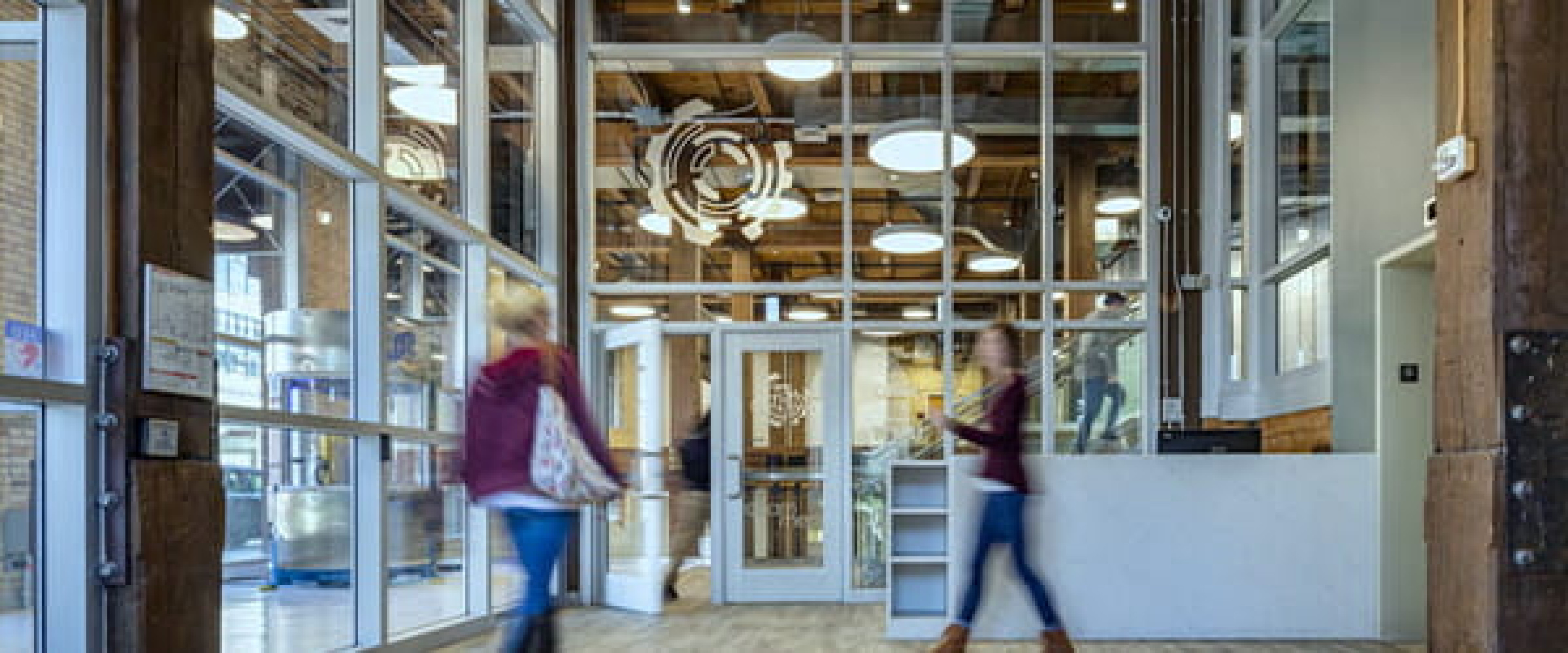 Two ladies walking through the entry way at the AMP Labs in Grand Rapids